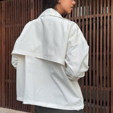 Chaqueta blanca casual con cuello alto y mangas largas, corte ajustado.