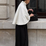 Elegante capa corta con cuello alto sencillo.