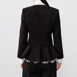 Elegante abrigo de lana negro con pliegues en la cintura.
