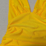 Vestido de noche largo con espalda abierta, escote en pico y halter, y abertura.