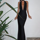 Vestido de noche largo con espalda abierta, escote en pico y halter, y abertura.