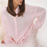 Blusa rosa estructurada con mangas largas y cintura atada.
