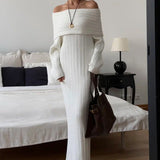 Elegante y minimalista vestido largo con hombros descubiertos en tejido de punto liso.