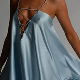 Vestido de noche sexy con detalle de cadena y espalda abierta pronunciada.