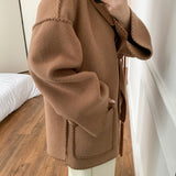 Abrigo de lana liso con bordado, cuello con pompones y bufanda.