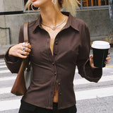 Blusa de cuello polo a rayas con botones en la parte delantera y cintura ajustada.