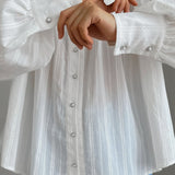 Blusa blanca de algodón jacquard con cuello alto