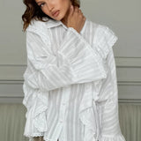 Elegante blusa jacquard con mangas acampanadas y mangas anchas.