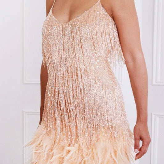 Vestido de noche con tirantes finos y lentejuelas, adornado con plumas.