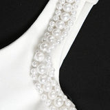Elegante vestido de noche con tirantes de perlas.