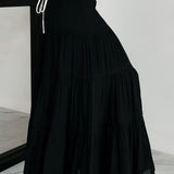 Falda larga de corte A con cintura alta y cordón en contraste, estilo bohemio chic.
