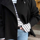 Elegante abrigo de lana liso con botones y cuello alto.