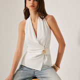 Blusa sin mangas con escote cruzado y detalles metalizados.