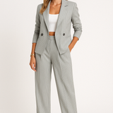 Traje de mujer: Blazer cruzado entallado y pantalón ancho de cintura alta.