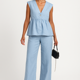Conjunto de dos piezas para mujer: Top peplum sin mangas con escote en pico y pantalón largo fluido.