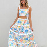 Conjunto de mujer: Top corto ajustado con tirantes anchos y falda larga con volantes y estampado floral.
