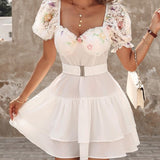 Vestido de mujer con hombros descubiertos, cinturón ancho, mangas asimétricas y falda con volantes.