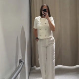 Conjunto de mujer: Chaqueta corta abotonada de manga corta y pantalón ancho de sastre.