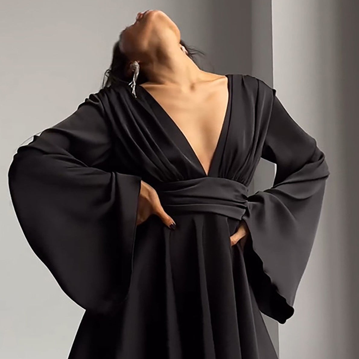 Vestido corto entallado de manga larga y escote en pico con lazo.