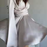Vestido corto entallado de manga larga y escote en pico con lazo.