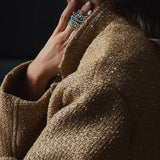 Chaqueta de lentejuelas con cuello alto y bolsillos.
