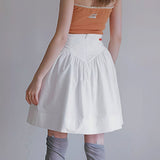 Falda mini juvenil vintage de talle alto, plisada y estampado de tulipanes.