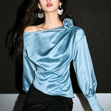 Blusa con hombros descubiertos y detalles rosas en relieve