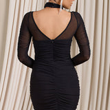 Vestido mini ajustado con cuello halter, diseño con hombros descubiertos y mangas largas.
