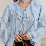 Elegante blusa de gasa lisa con volantes y lazo.