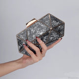 Bolso de hombro de acrílico y metal adornado con diamantes.