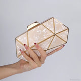 Bolso de hombro de acrílico y metal adornado con diamantes.