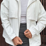 Chaqueta blanca casual con cuello alto y mangas largas, corte ajustado.