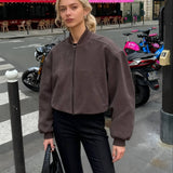 Chaqueta de aviador retro de ante gris con cuello alto y cierre de cremallera.