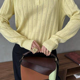 Blusa holgada con cuello polo jacquard y mangas largas.