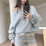 Sudadera asimétrica con hombros descubiertos, remaches y corte holgado.