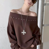 Sudadera asimétrica con hombros descubiertos, remaches y corte holgado.