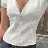 Blusa con aplicaciones de encaje, escote en pico y mangas abullonadas.