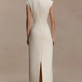 Elegante vestido largo con corte asimétrico y ribete metálico fruncido.