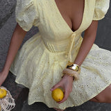 Mini vestido de algodón amarillo con bordado y lazo en la cintura.