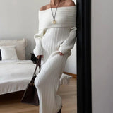 Elegante y minimalista vestido largo con hombros descubiertos en tejido de punto liso.