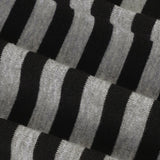 Blusa asimétrica de rayas blancas y negras con un hombro y manga larga, corte entallado.