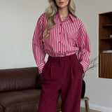 Blusa británica distintiva con rayas rojas y mangas largas.