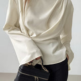 Blusa de gasa color albaricoque con mangas acampanadas y cuello alto