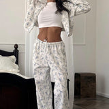 Conjunto de dos piezas: sudadera corta con cremallera y cordón, pantalones anchos y acampanados, estampado floral.