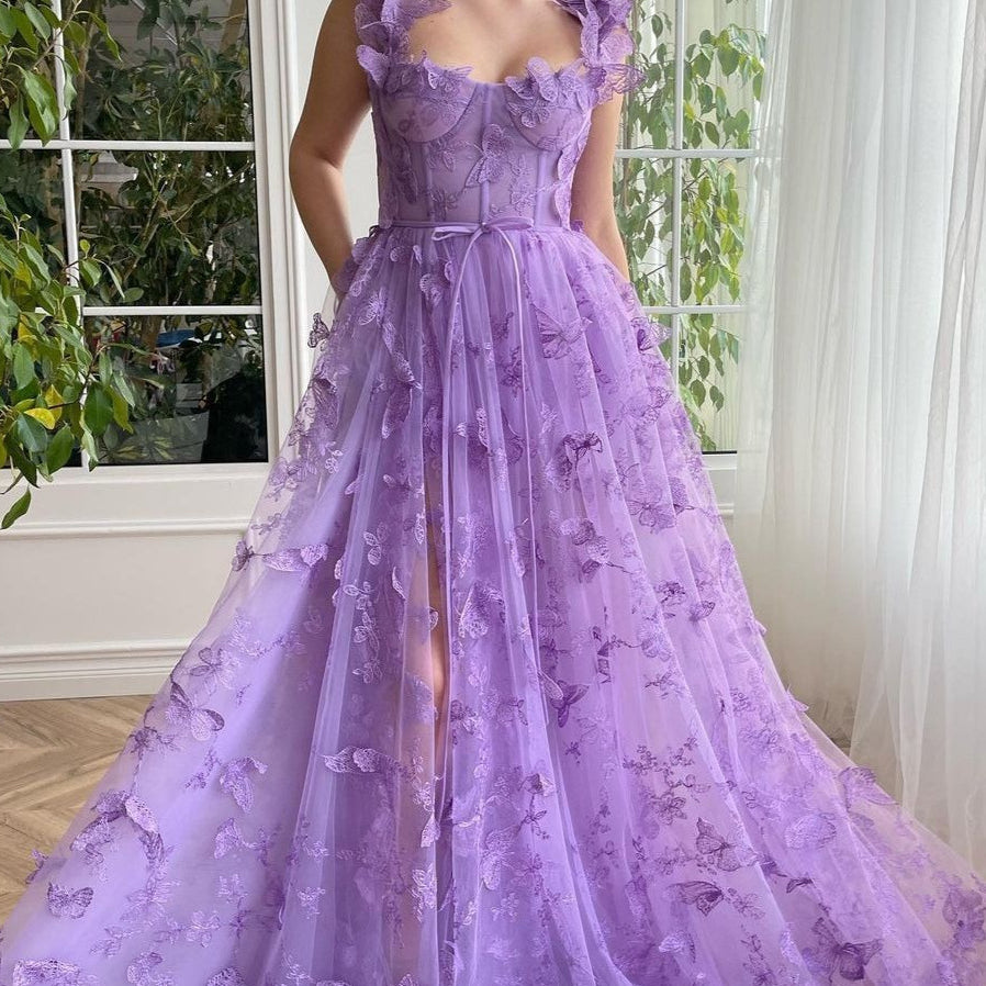 Vestido de noche con abertura en tul transparente con tirantes finos y abertura alta.
