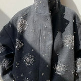 Abrigo de cuello alto adornado con perlas y lentejuelas.