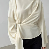 Blusa de gasa de seda beige con cintura anudada y mangas acampanadas, con cinturón para anudar.