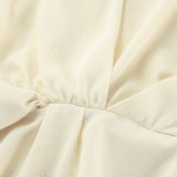 Blusa de gasa de seda beige con cintura anudada y mangas acampanadas, con cinturón para anudar.