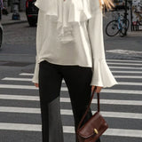 Blusa beige con volantes, escote en pico y mangas acampanadas