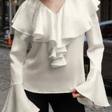 Blusa beige con volantes, escote en pico y mangas acampanadas